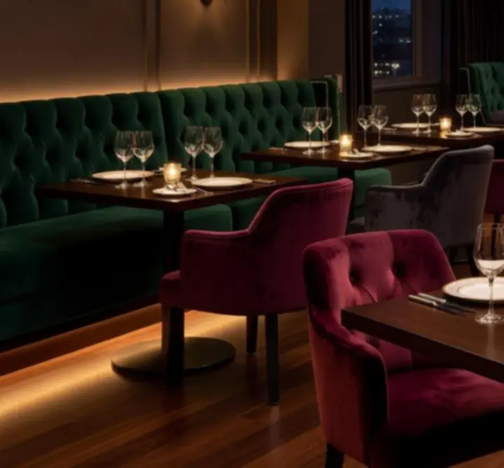 Signature dining tables set with glassware and warm lighting